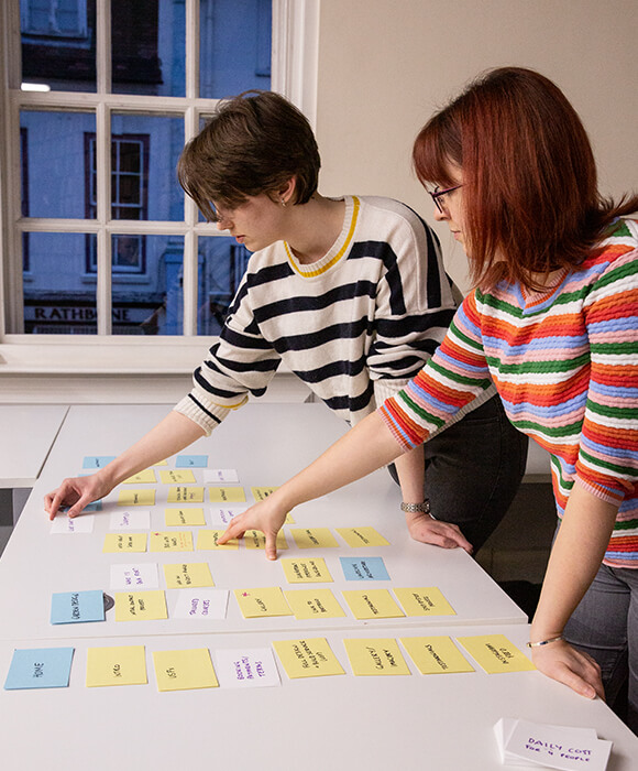 Two people sorting planning cards on a desk